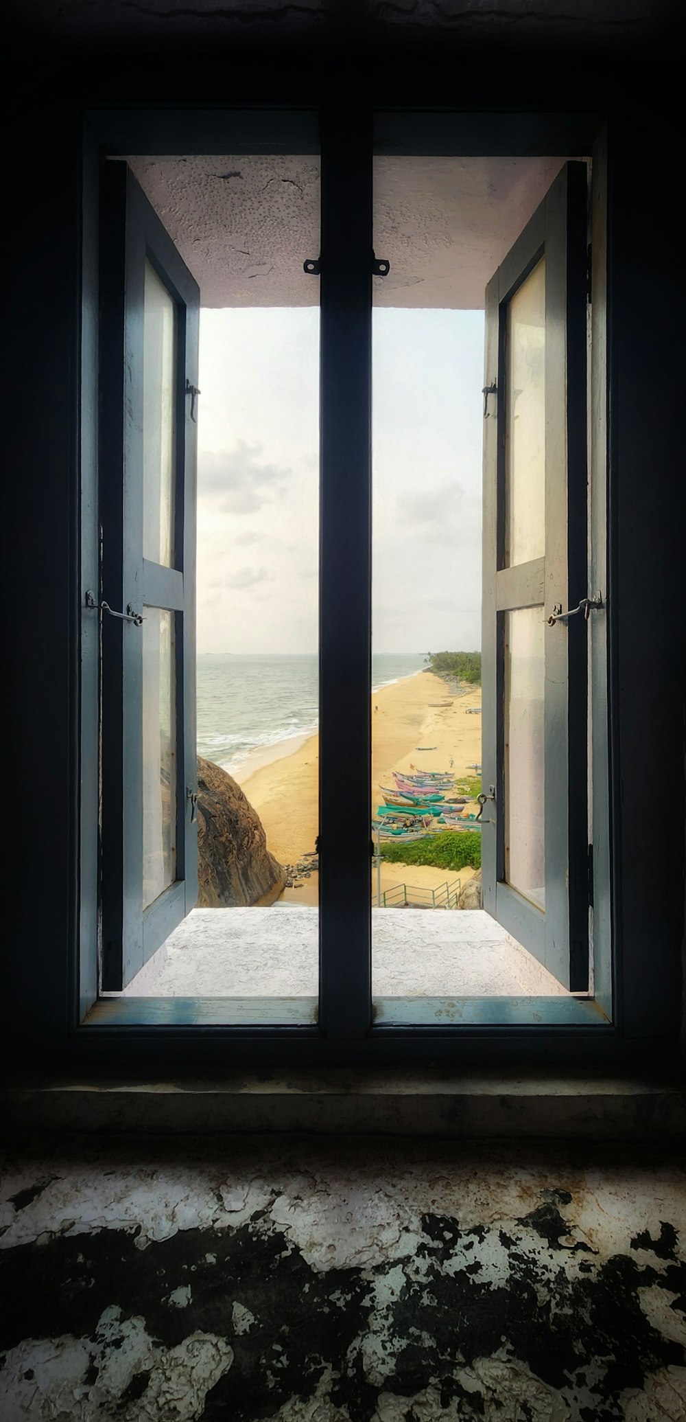 an open window with a view of a beach