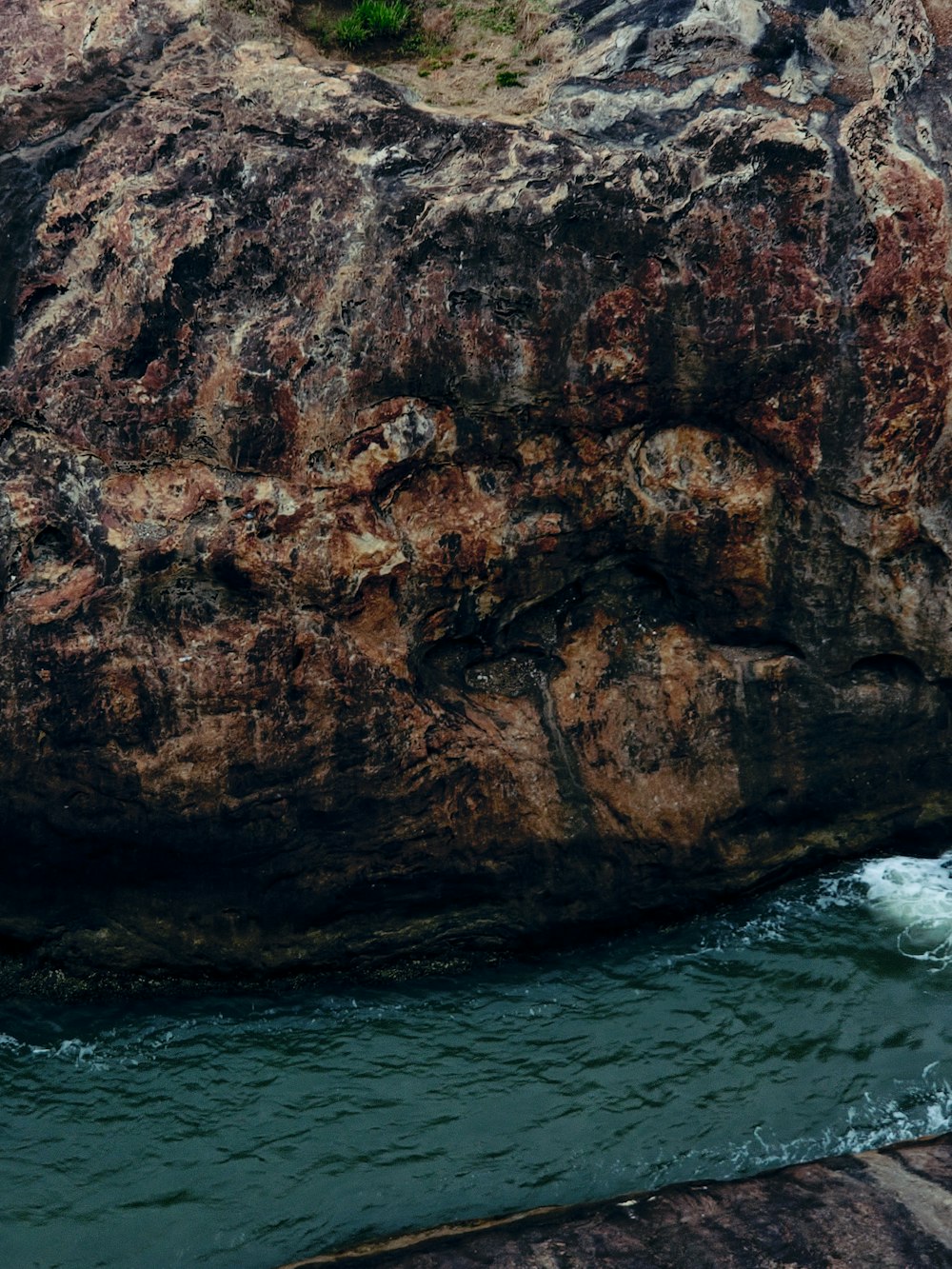 a man standing on a rock next to a body of water