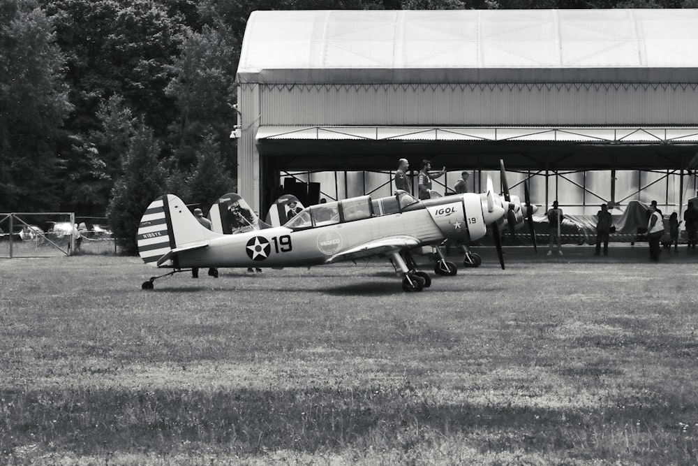 a small airplane sitting on top of a grass covered field