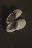 a pair of white shoes sitting on top of a floor