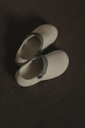 a pair of white shoes sitting on top of a floor