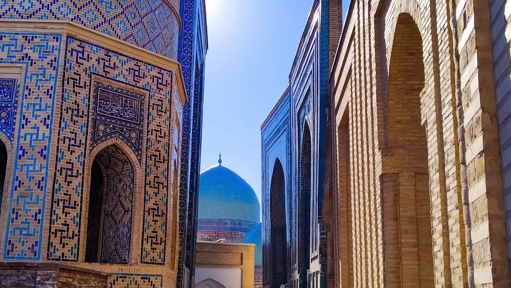 a narrow alley with a blue dome in the background
