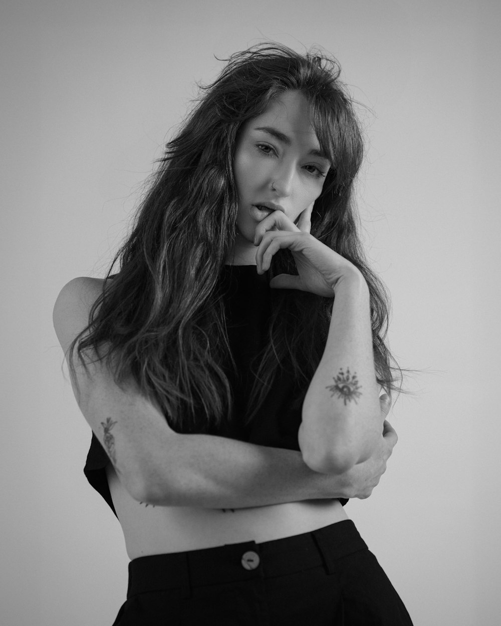 a black and white photo of a woman with her arms crossed