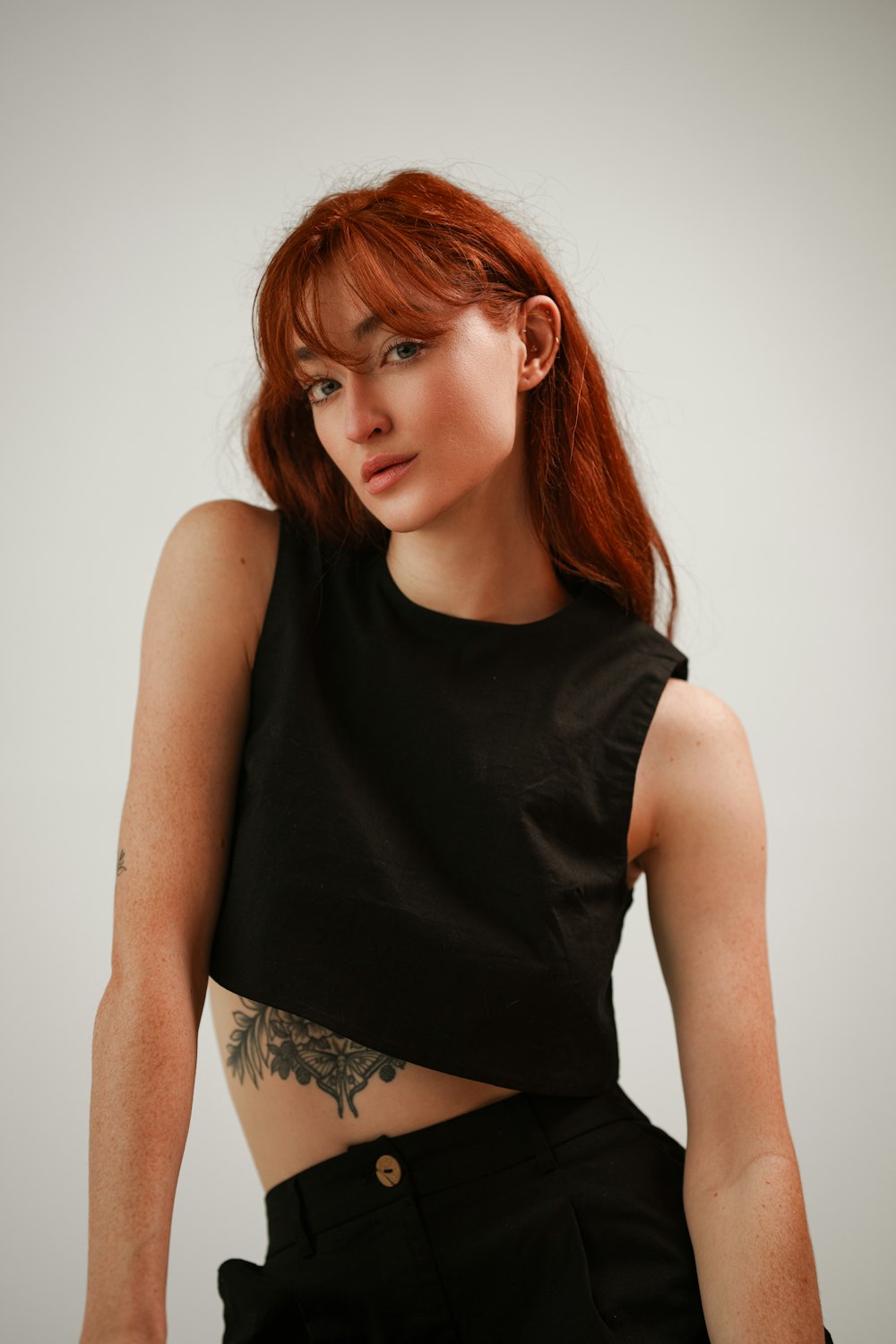 a woman with red hair wearing a black crop top