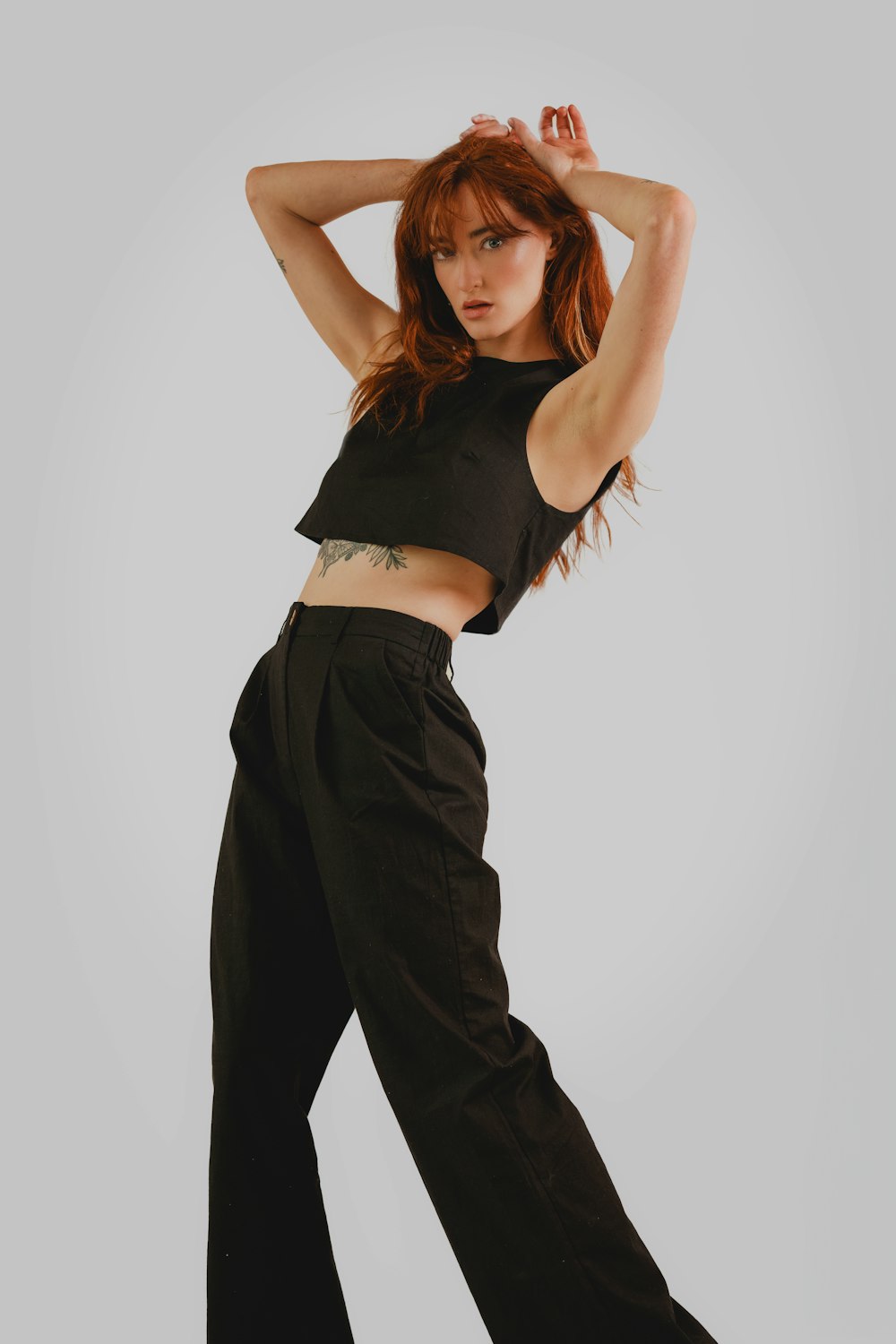 a woman in black pants and a crop top