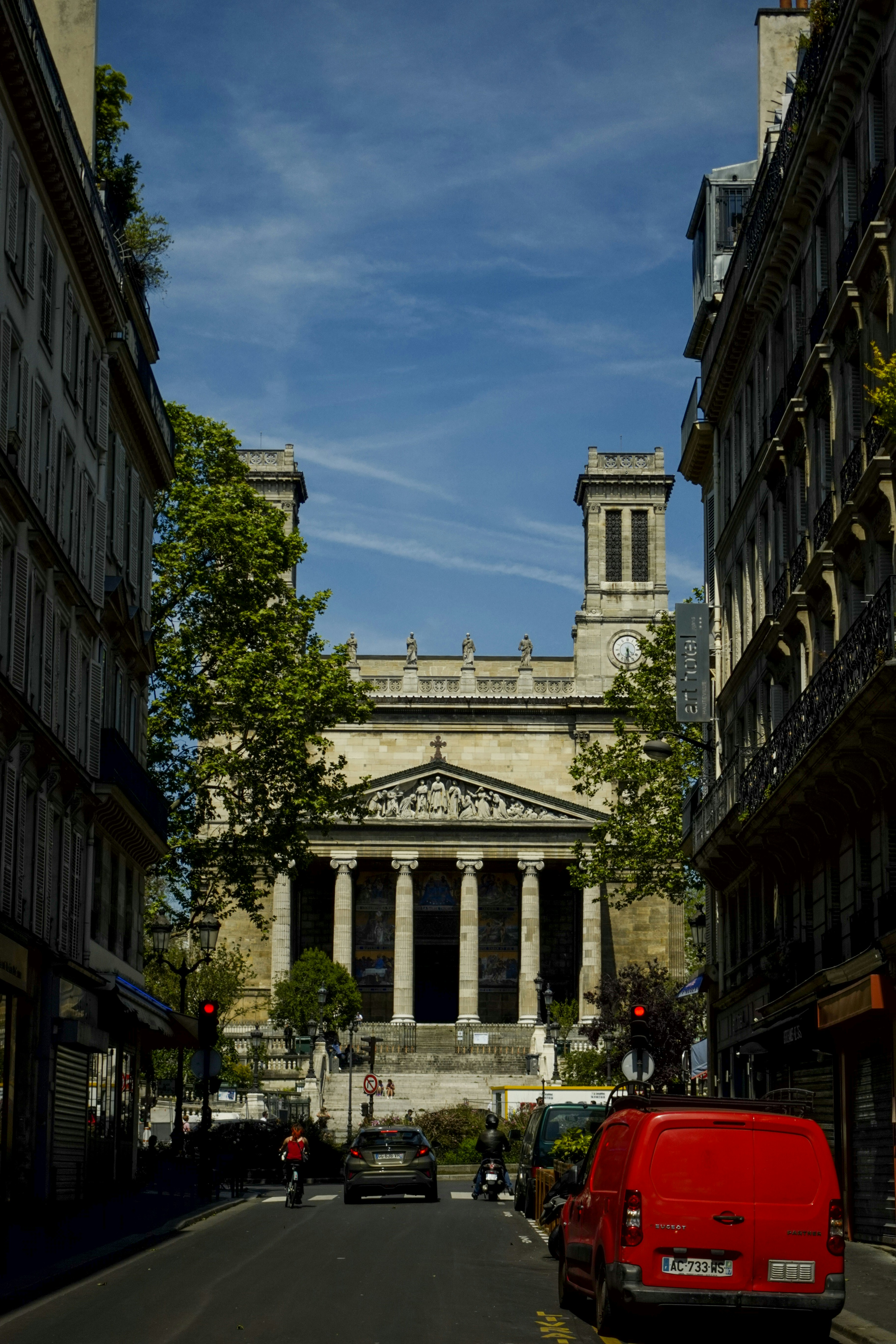 고층 건물 옆 거리를 달리는 빨간 밴