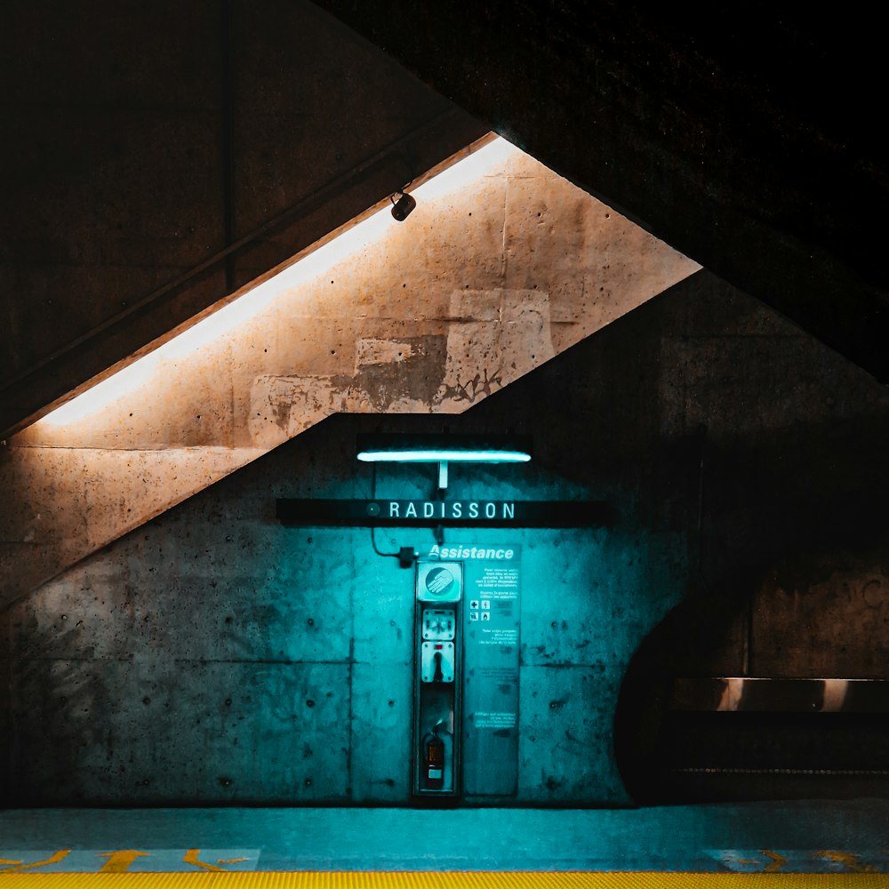 a subway station with a neon sign on the wall