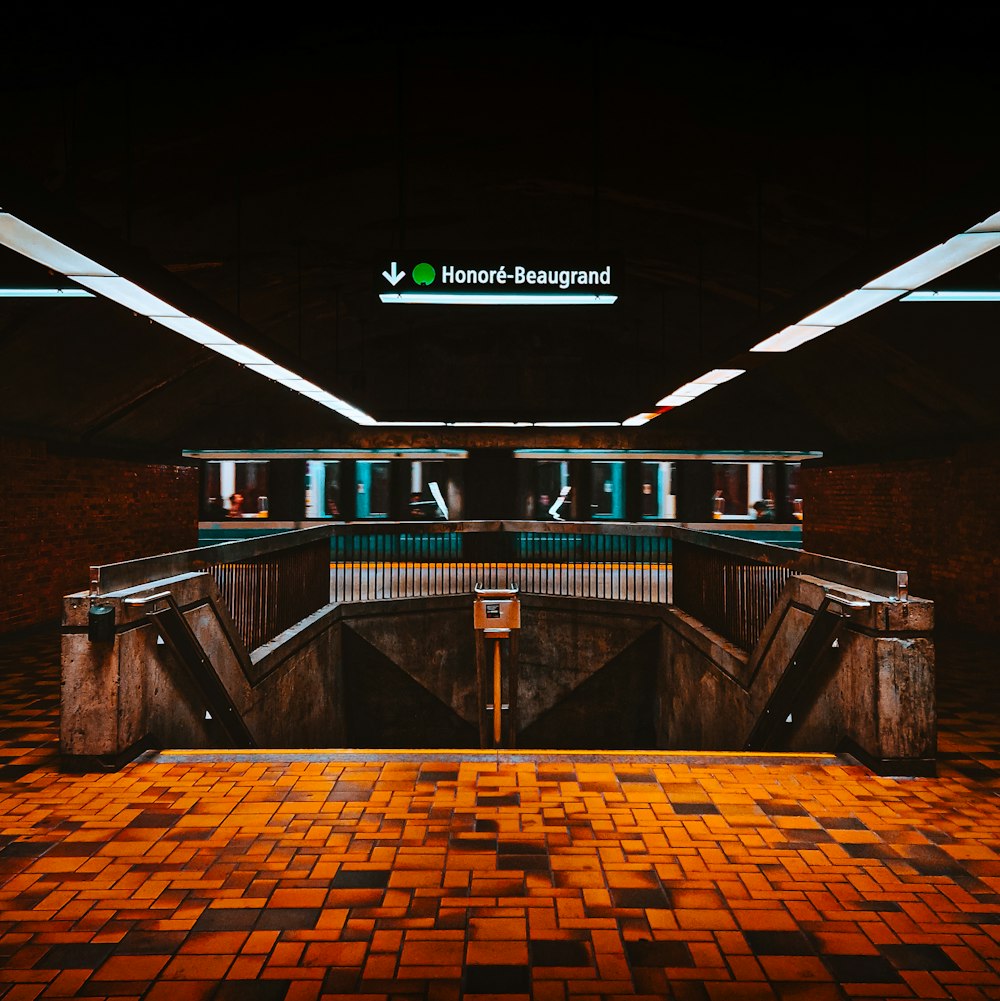 an empty subway station with a tiled floor