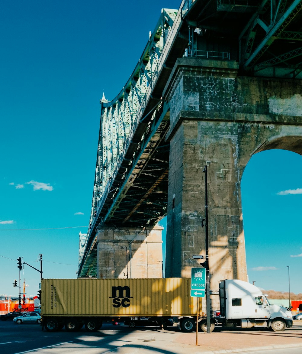 a semi truck is driving under a bridge