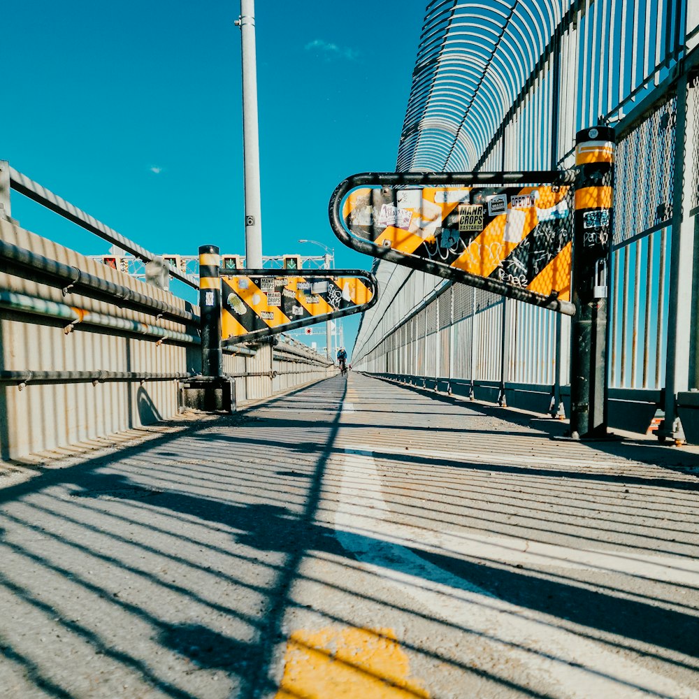 a pedestrian bridge with yellow and black railings