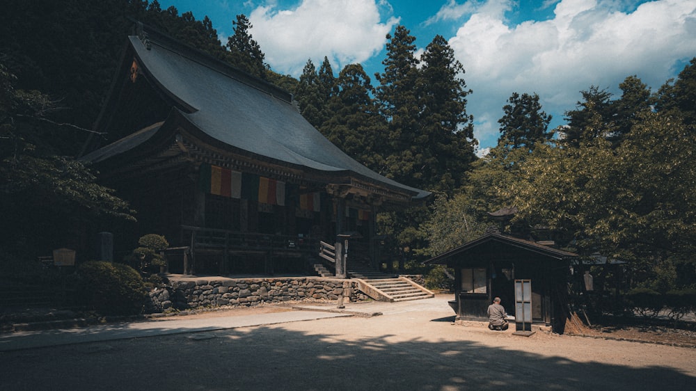 a person sitting on a bench in front of a building