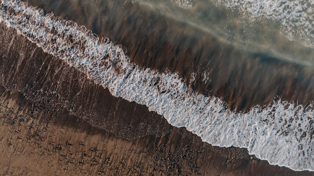 an aerial view of a beach with waves and sand