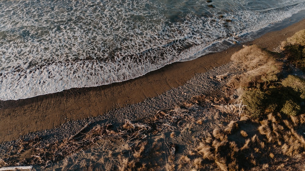 an aerial view of a beach with waves coming in