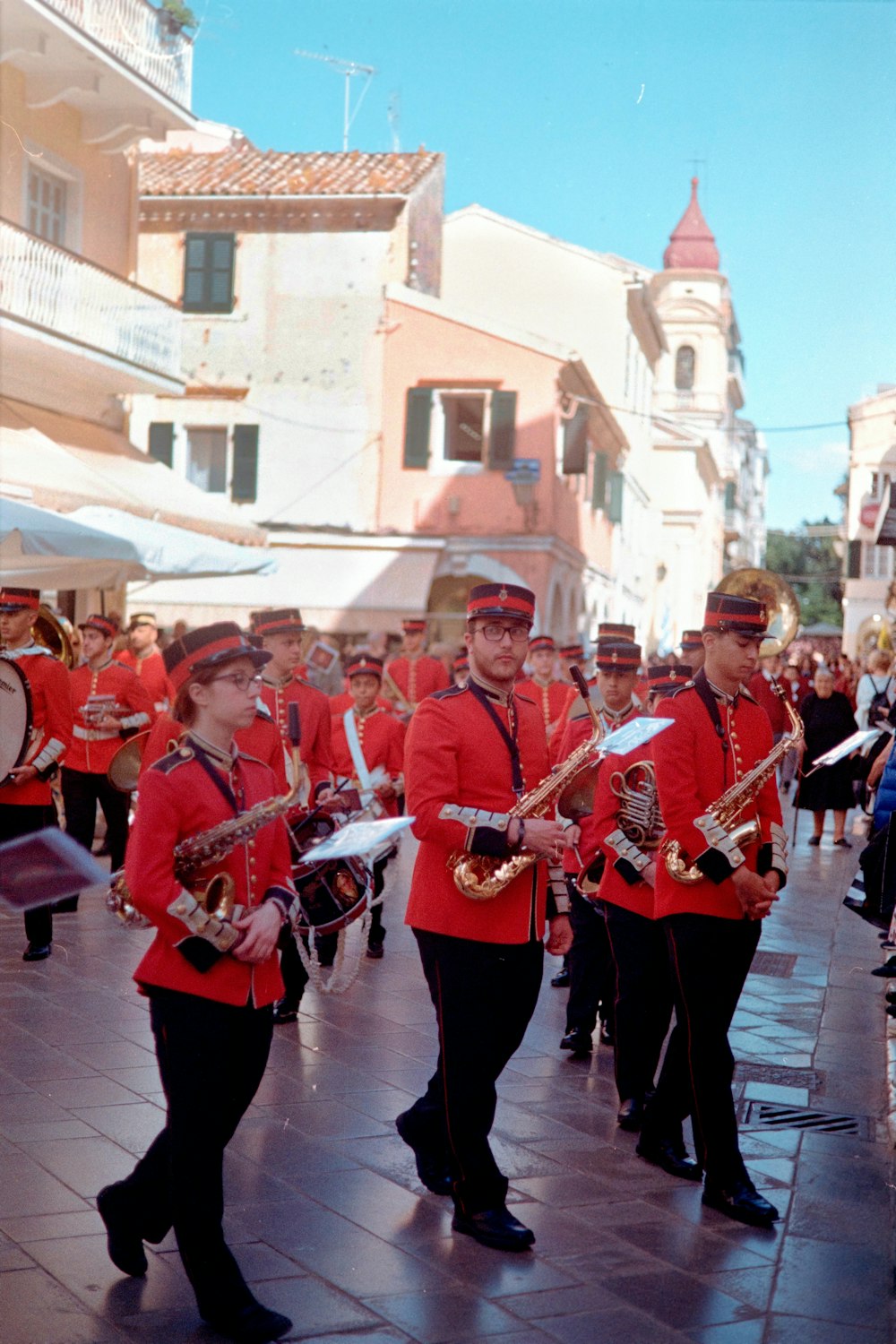 a group of men in red uniforms marching down a street