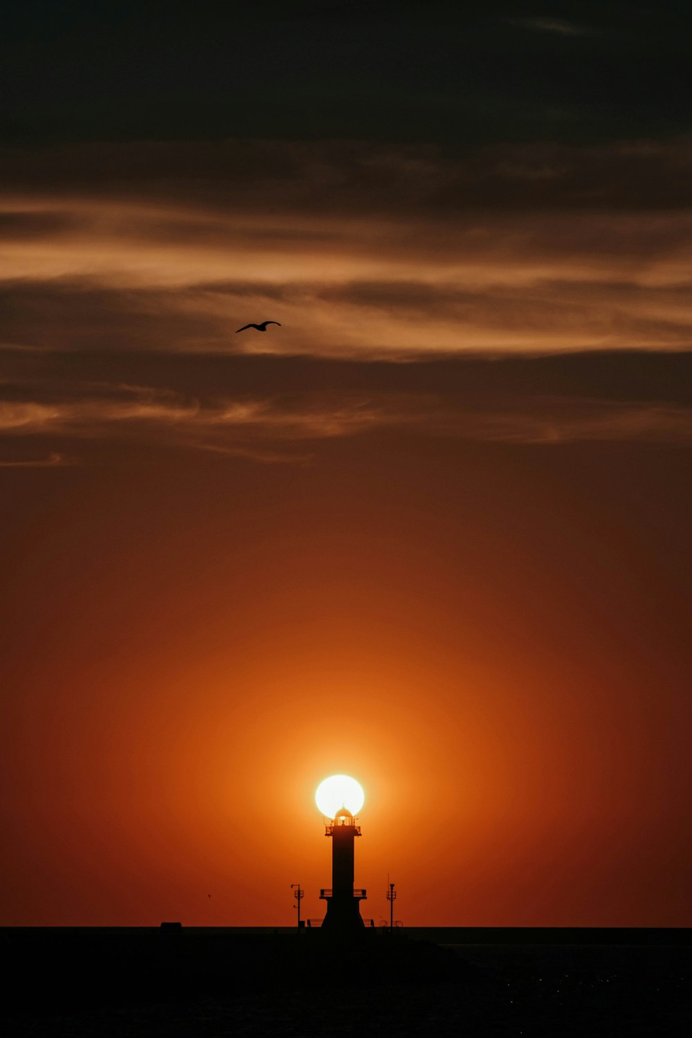 the sun is setting behind a light tower