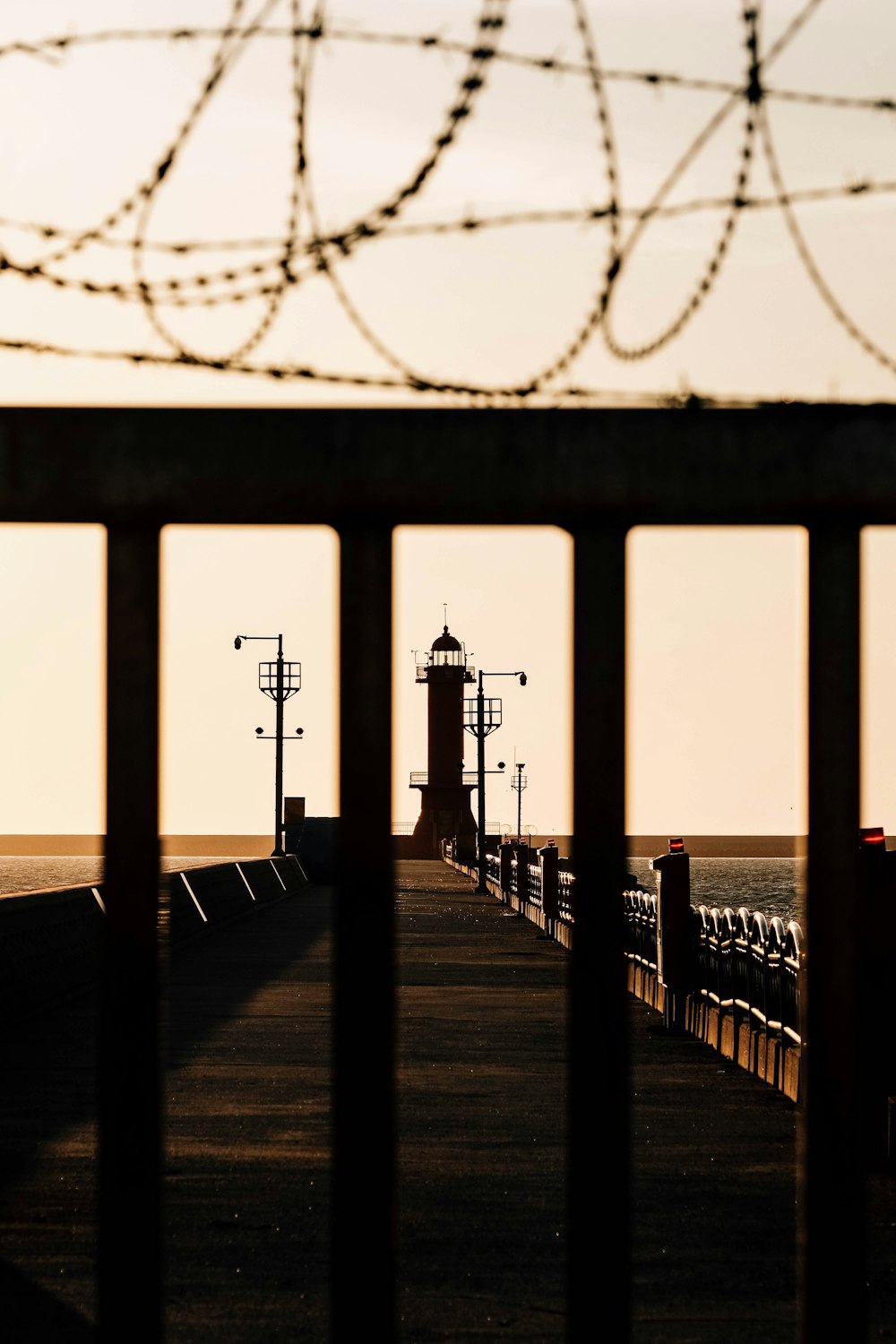 a view of a lighthouse through a fence