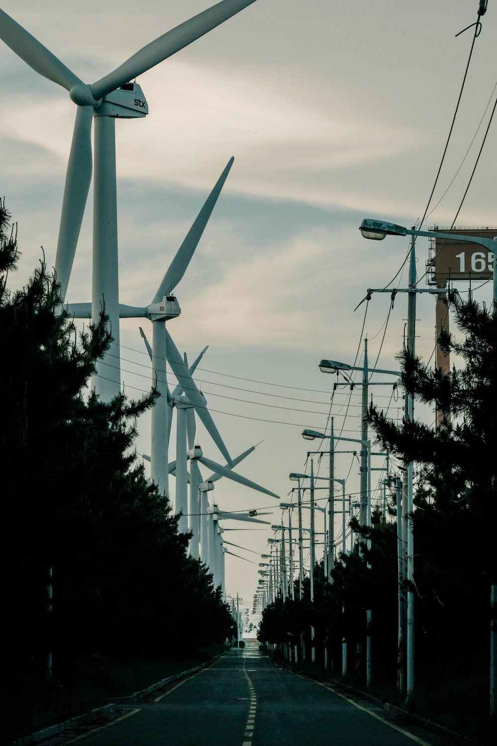 a street lined with lots of wind turbines