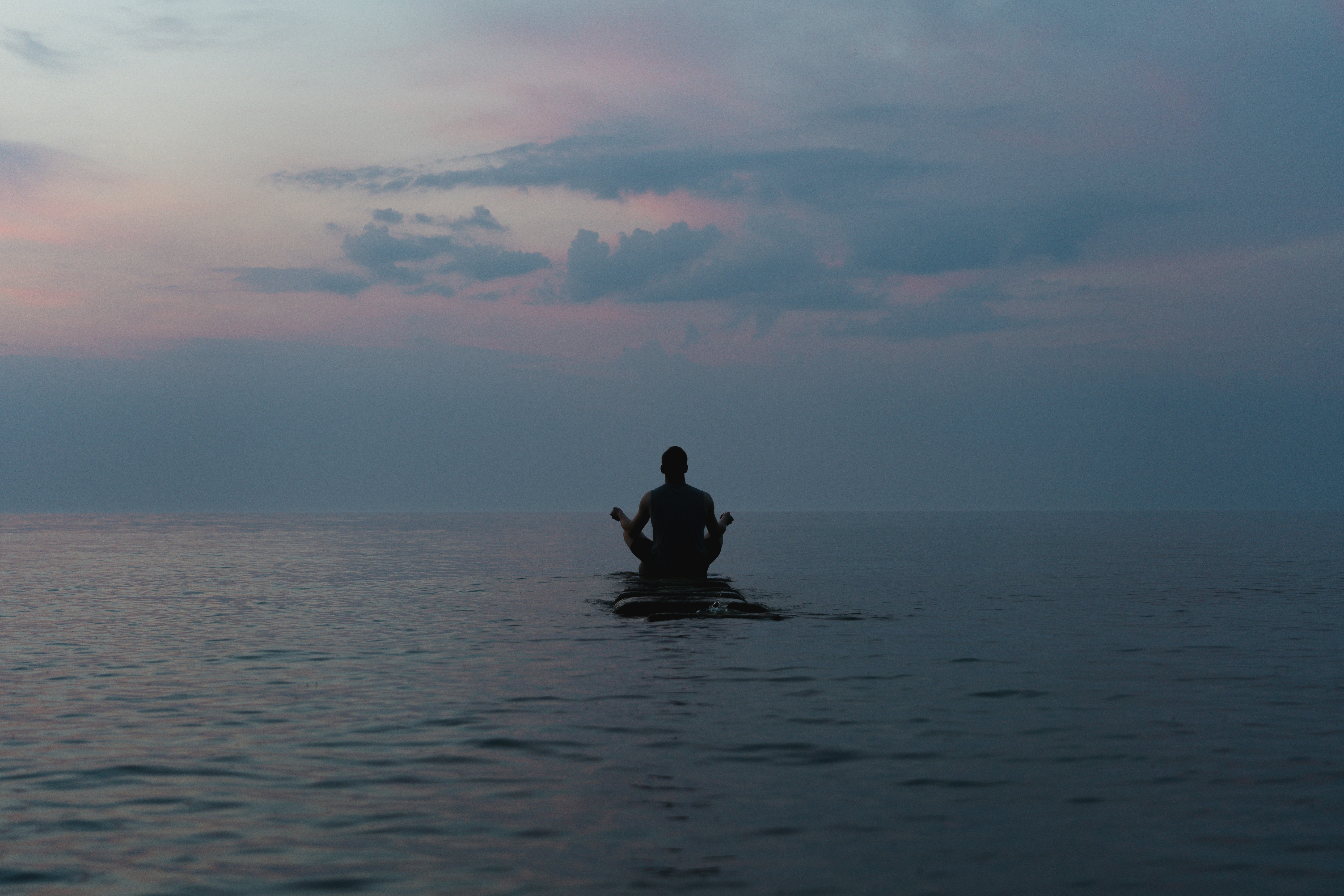 a man sitting on a surfboard in the middle of the ocean, 