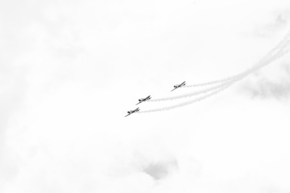 a group of airplanes flying through a cloudy sky