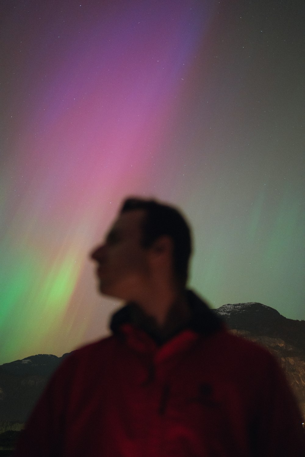 a man standing in front of a green and purple light