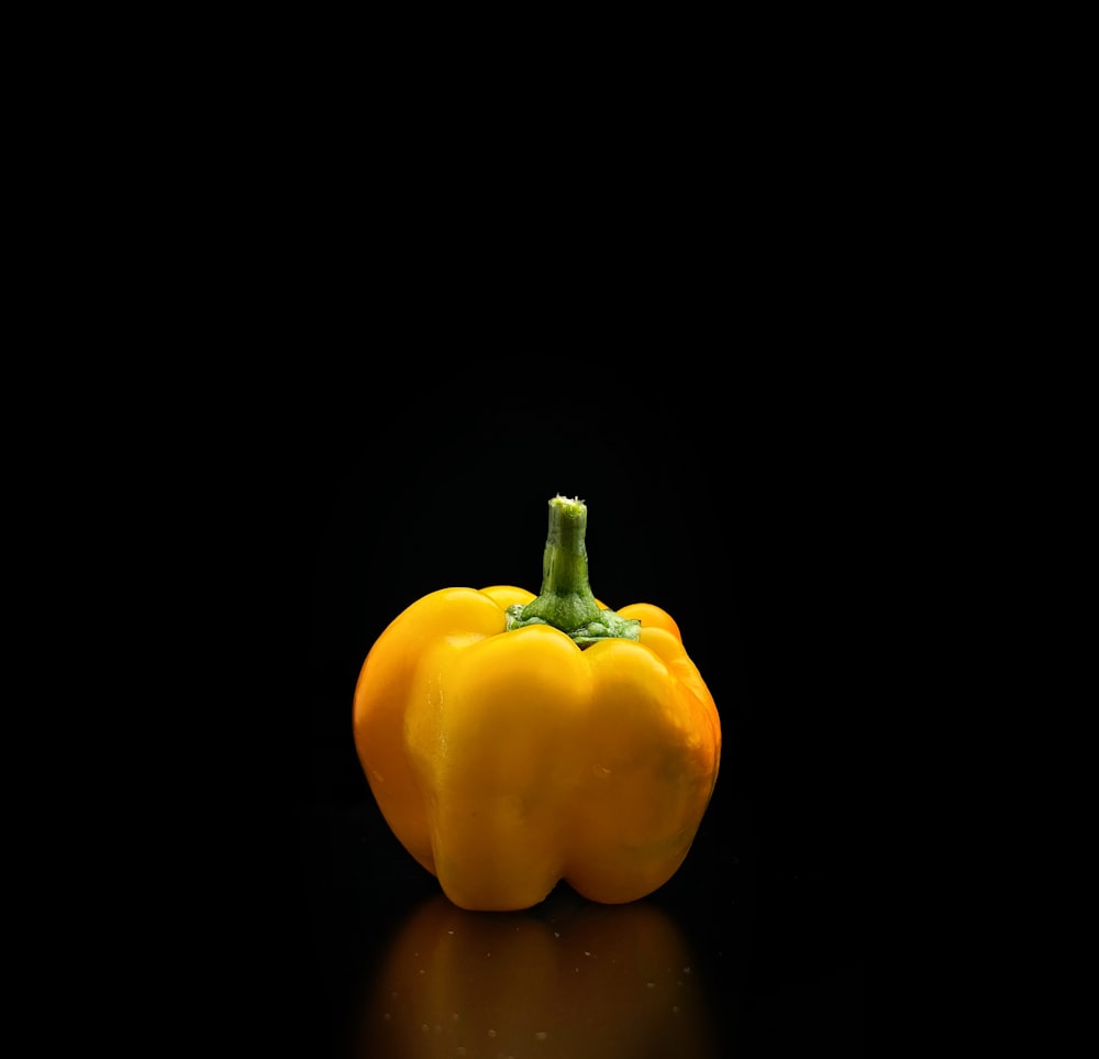 a yellow pepper on a black background