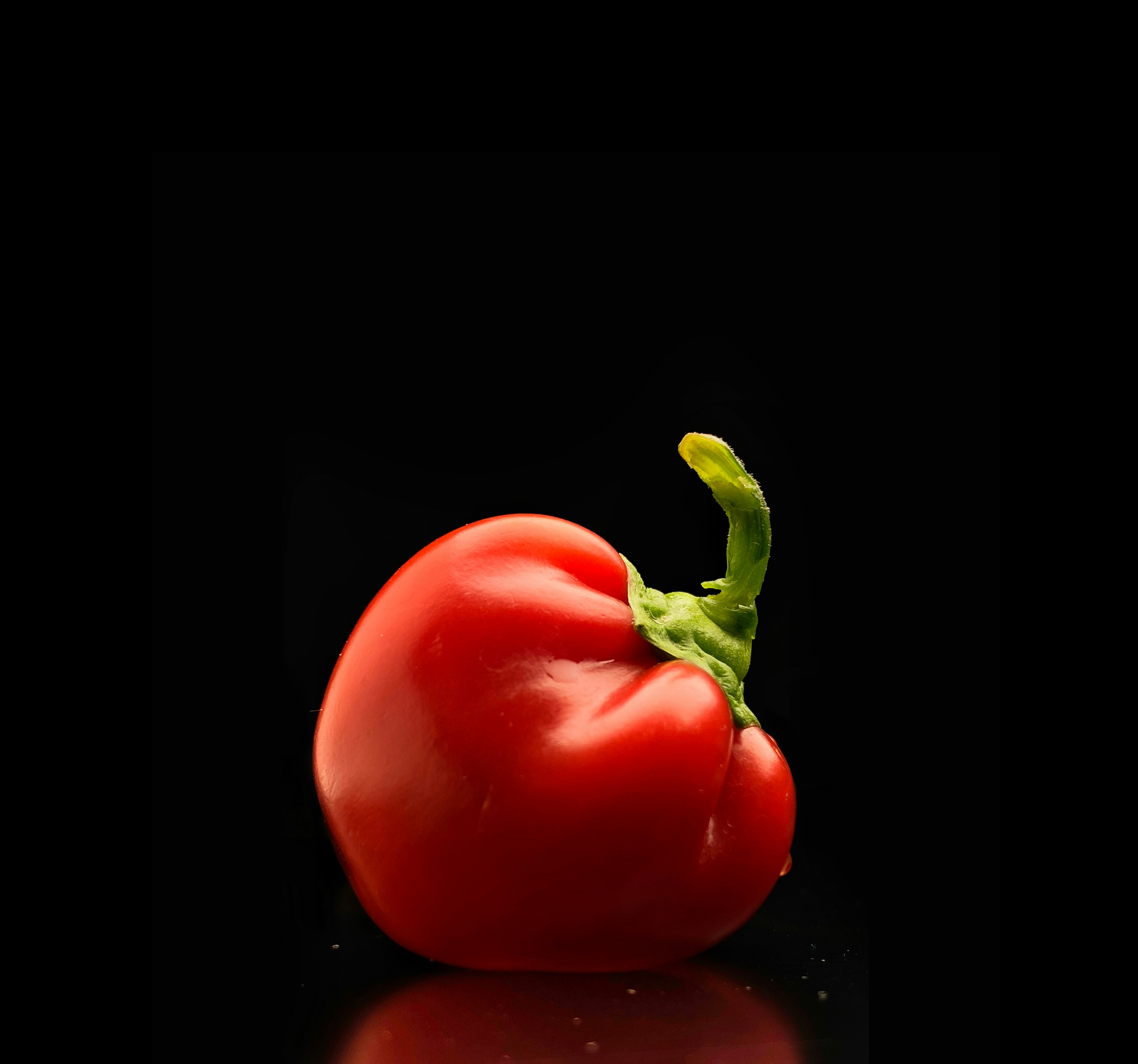 A close up of a tomato on a black background