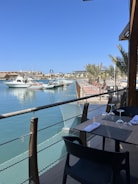 a table and chairs on a balcony overlooking the water