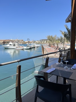a table and chairs on a balcony overlooking the water