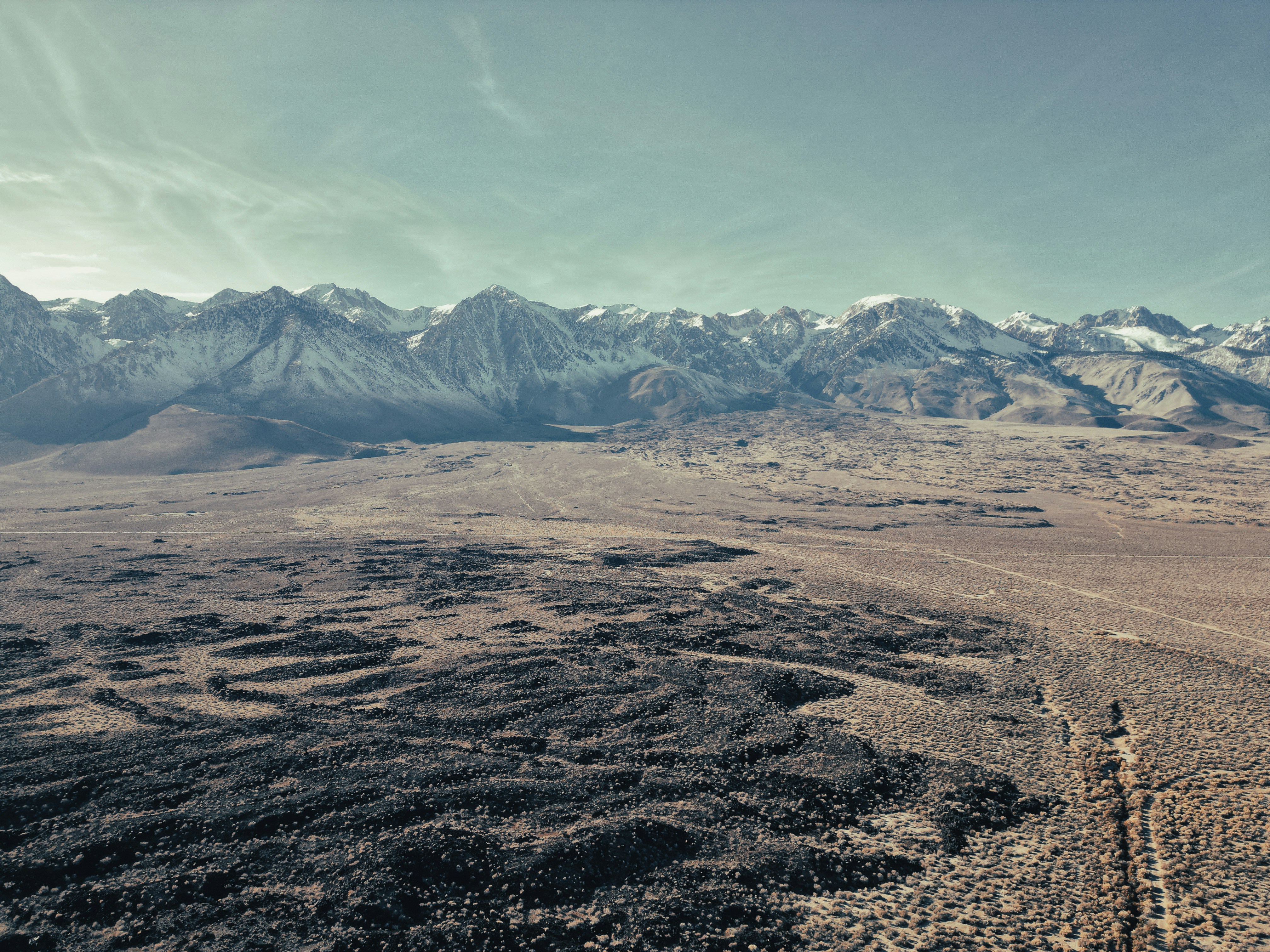 a dirt field with mountains in the background
