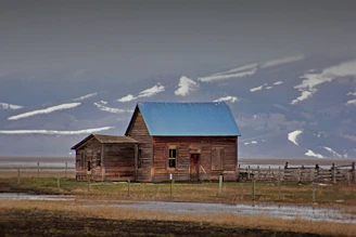 an old wooden house with a blue roof
