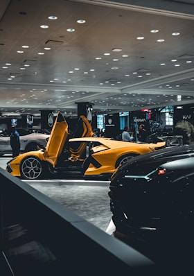 a yellow sports car parked in a showroom
