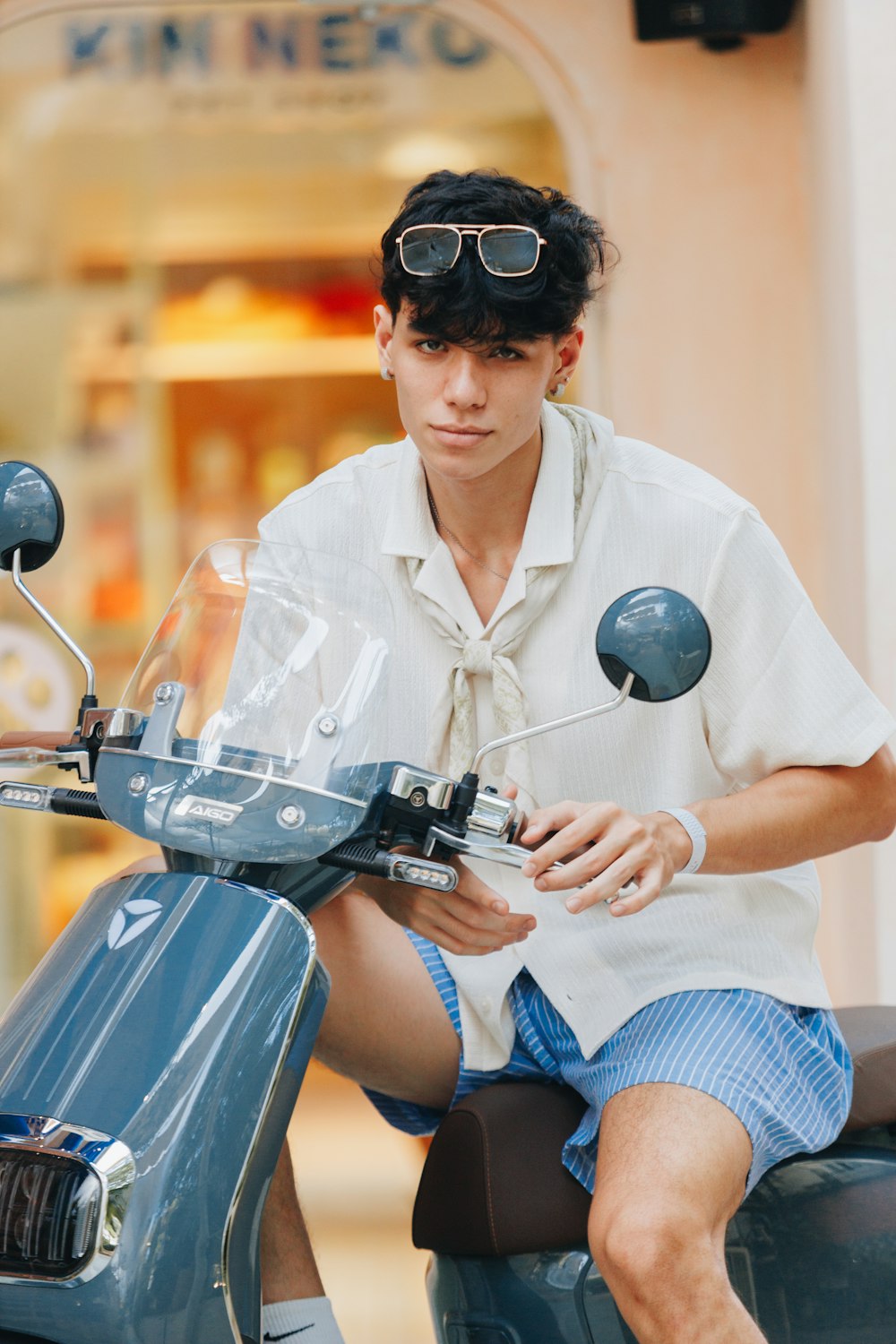 a man sitting on a scooter wearing sunglasses
