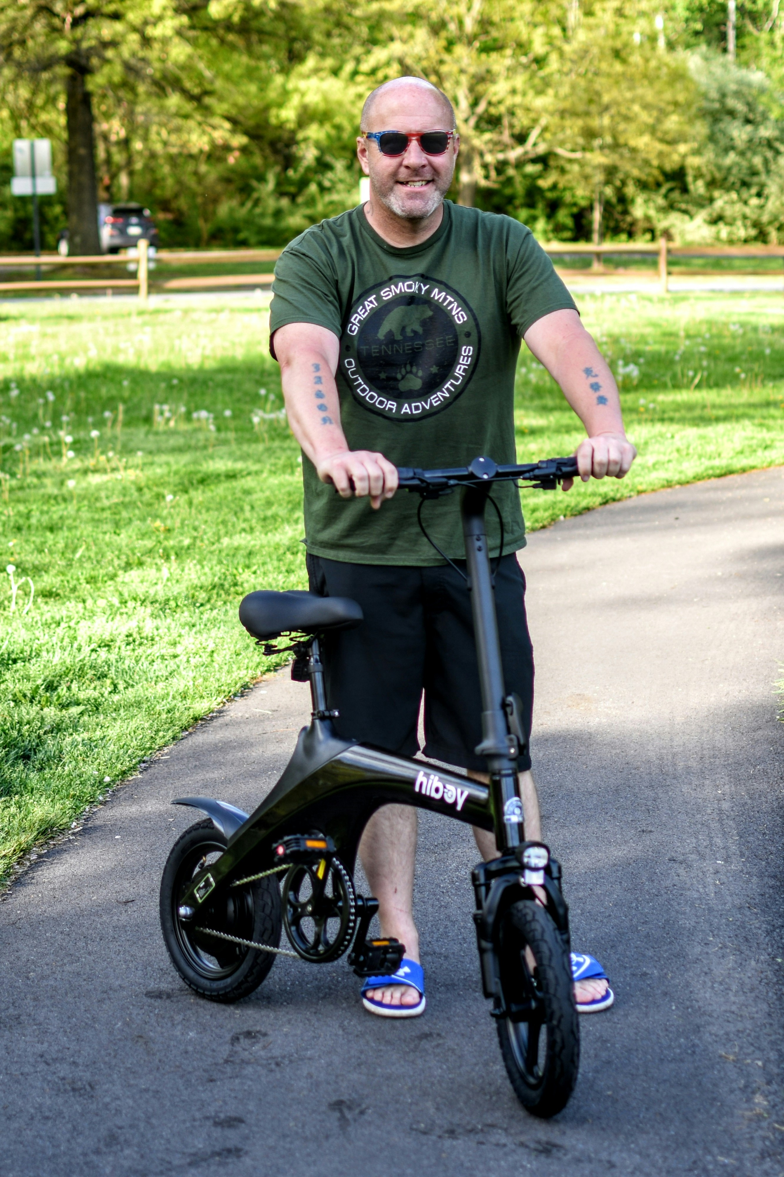 a man standing next to a black scooter