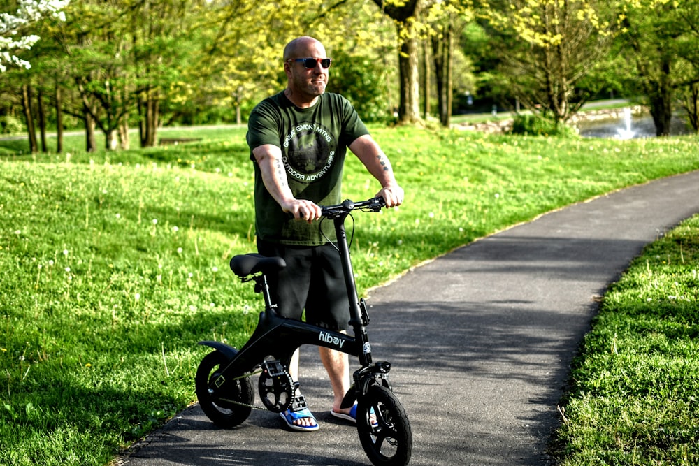 a man riding a scooter on a path in a park