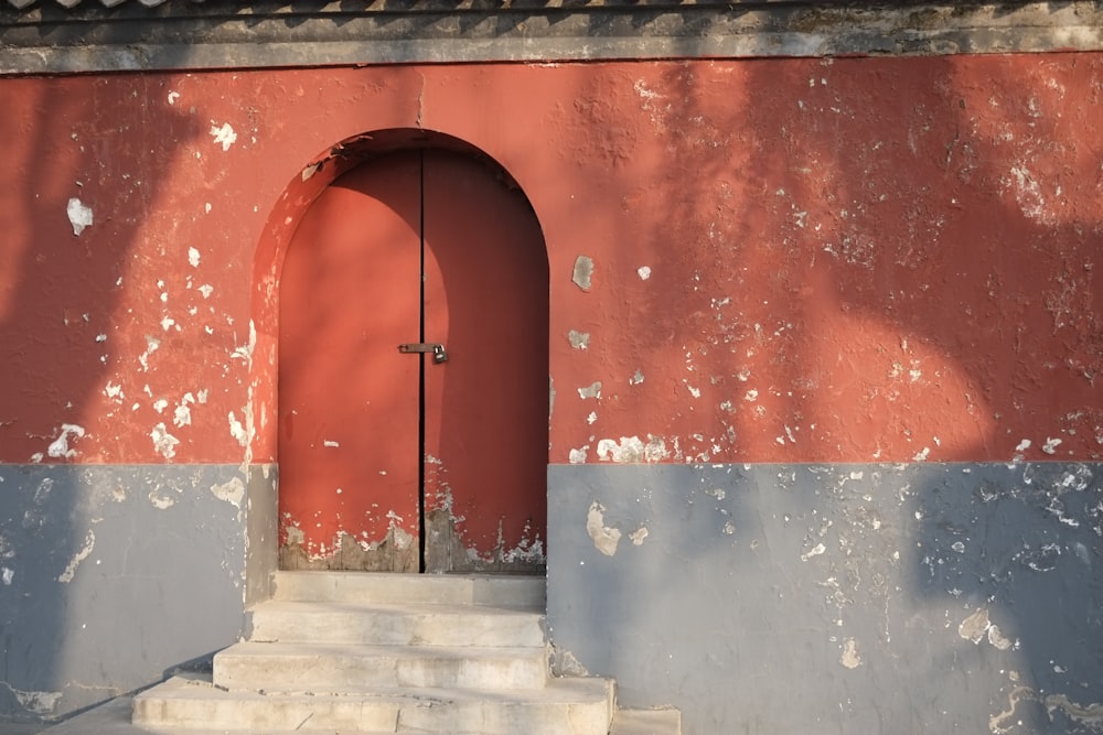 a red door and steps in front of a red wall