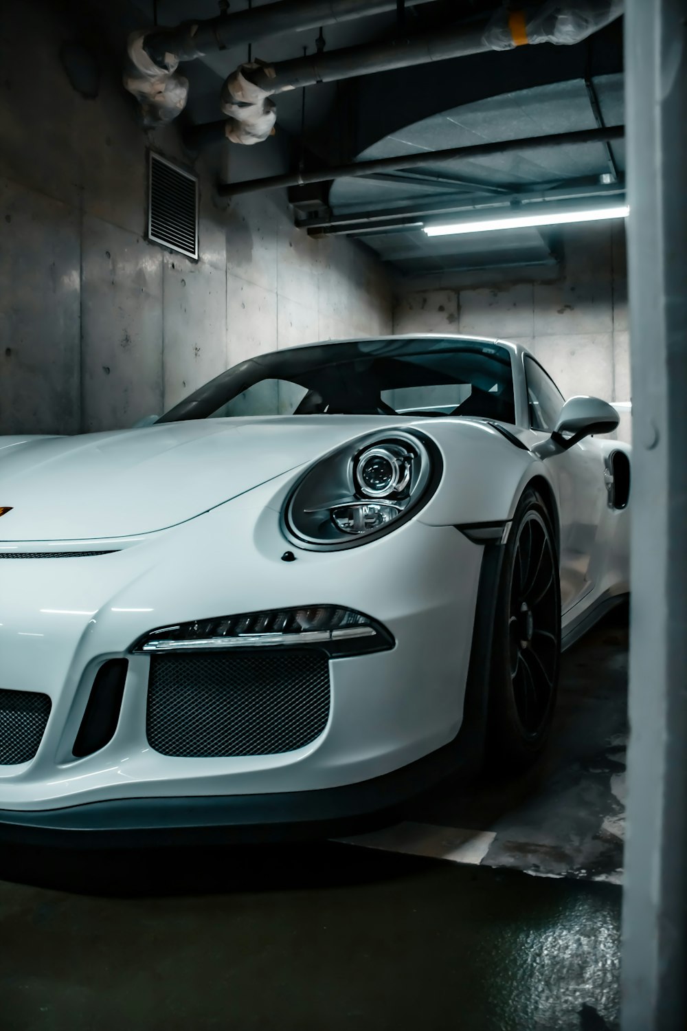 a white sports car parked in a garage