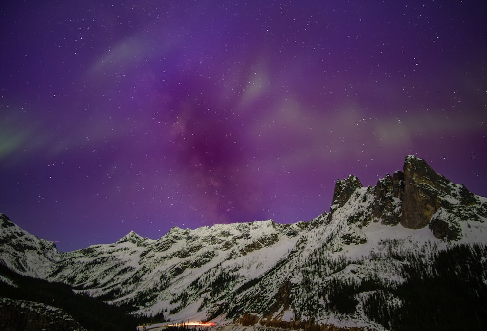 a mountain with a purple sky filled with stars