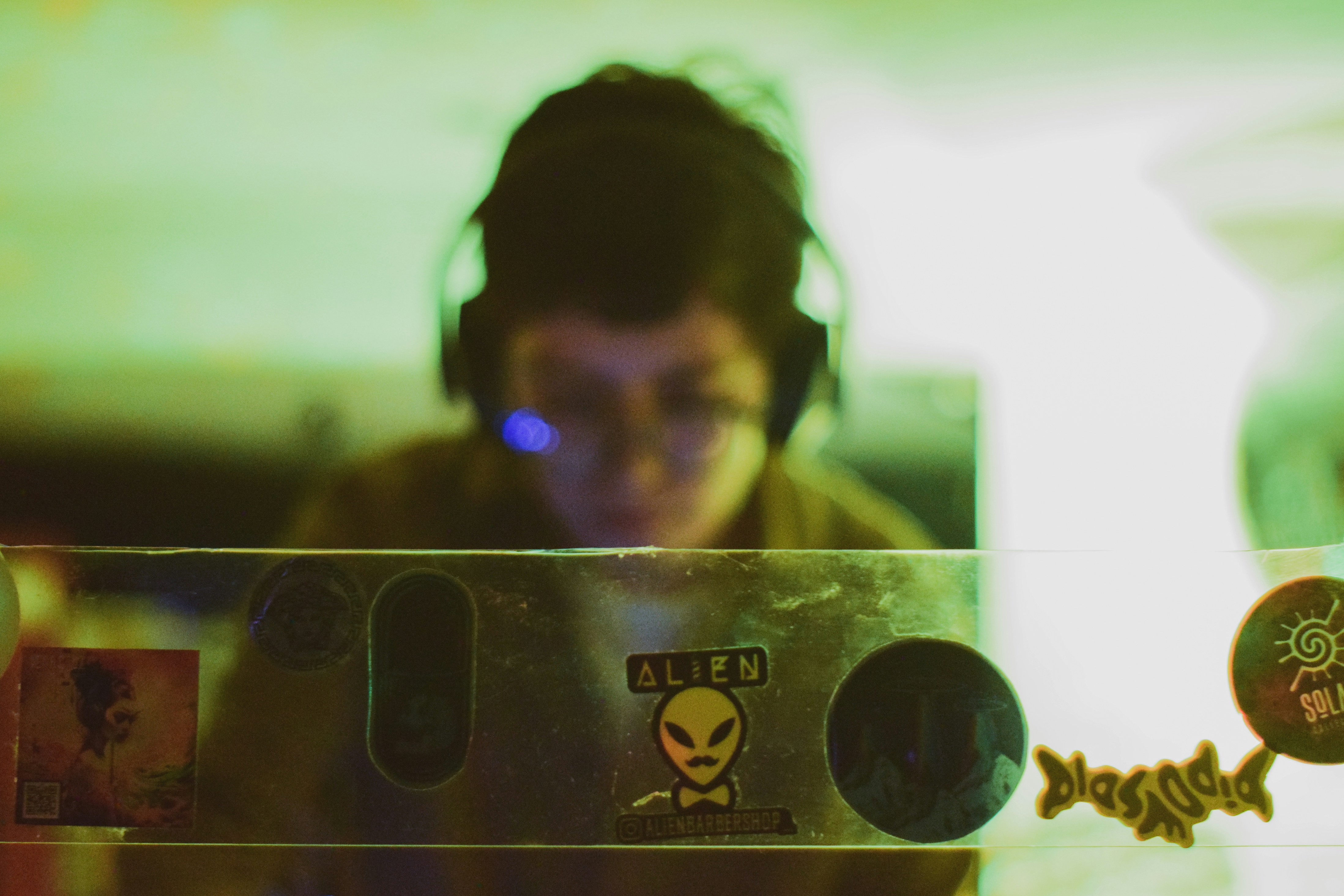 a man wearing headphones looking at a piece of metal