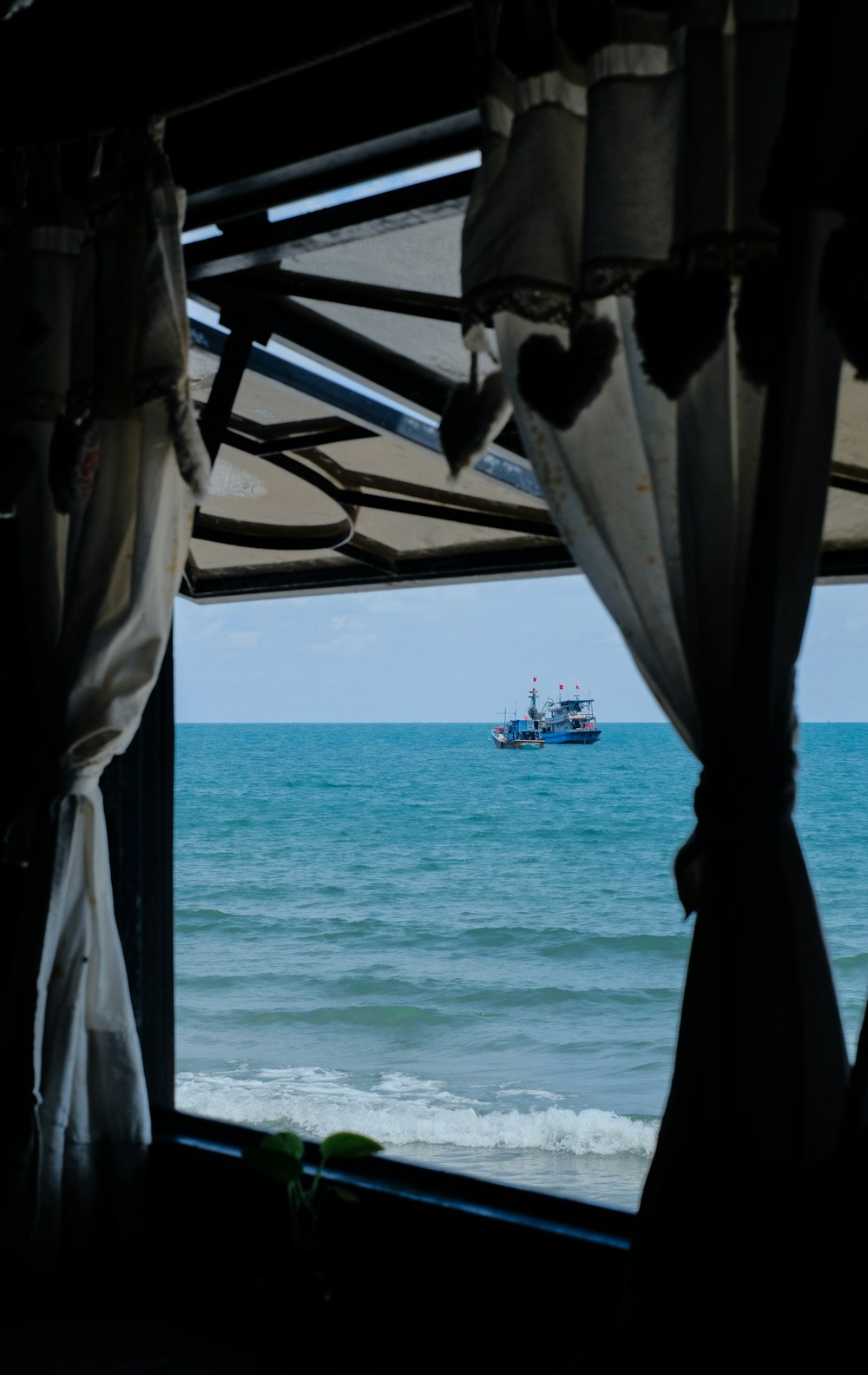 um barco no oceano visto através de uma janela