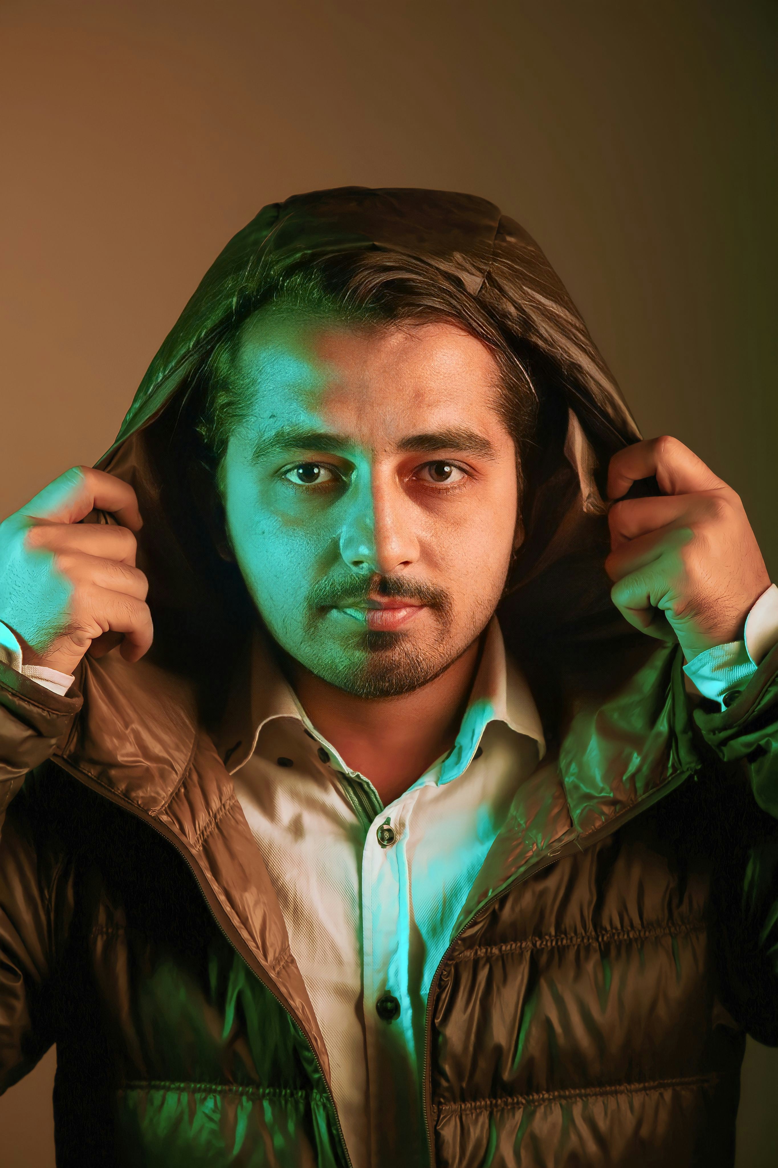 a man in a jacket is holding his jacket over his head