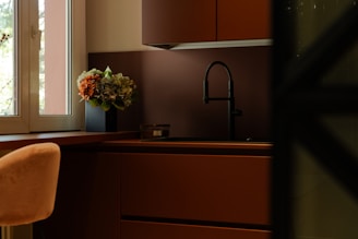 a vase of flowers sitting on a counter next to a window