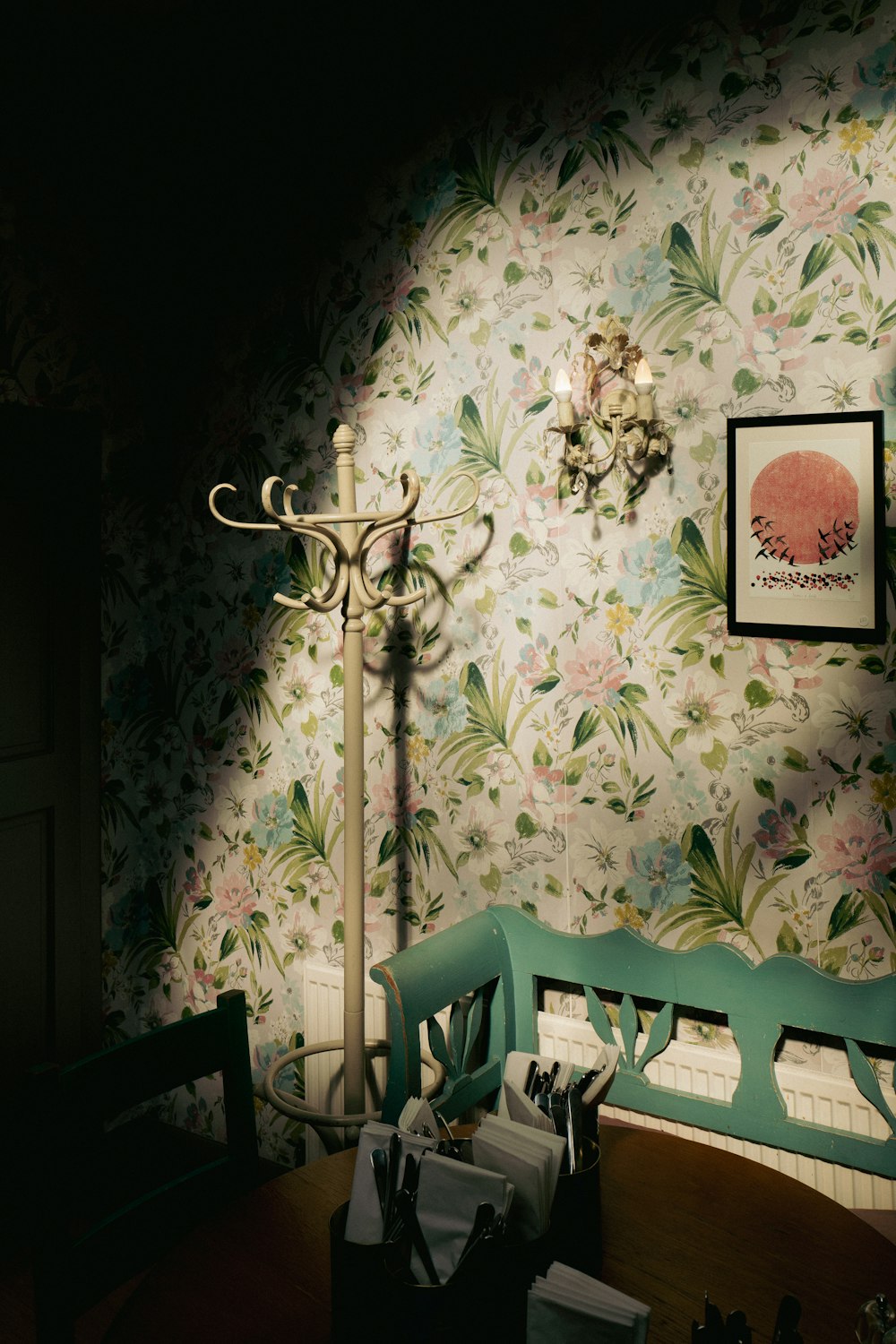 a room with a wallpapered wall and a lamp