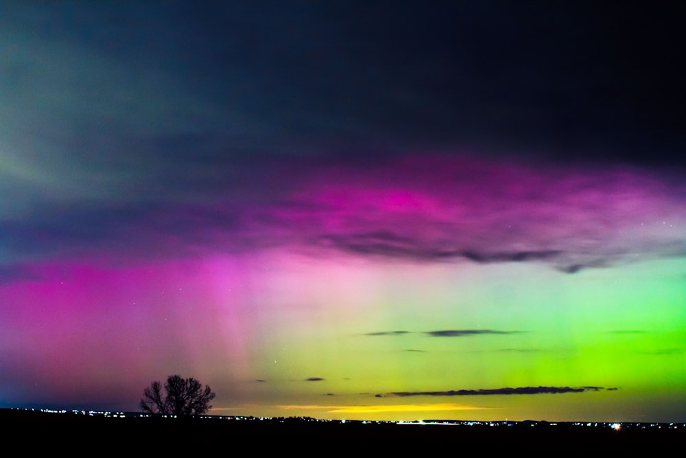 a very colorful sky with some clouds and trees