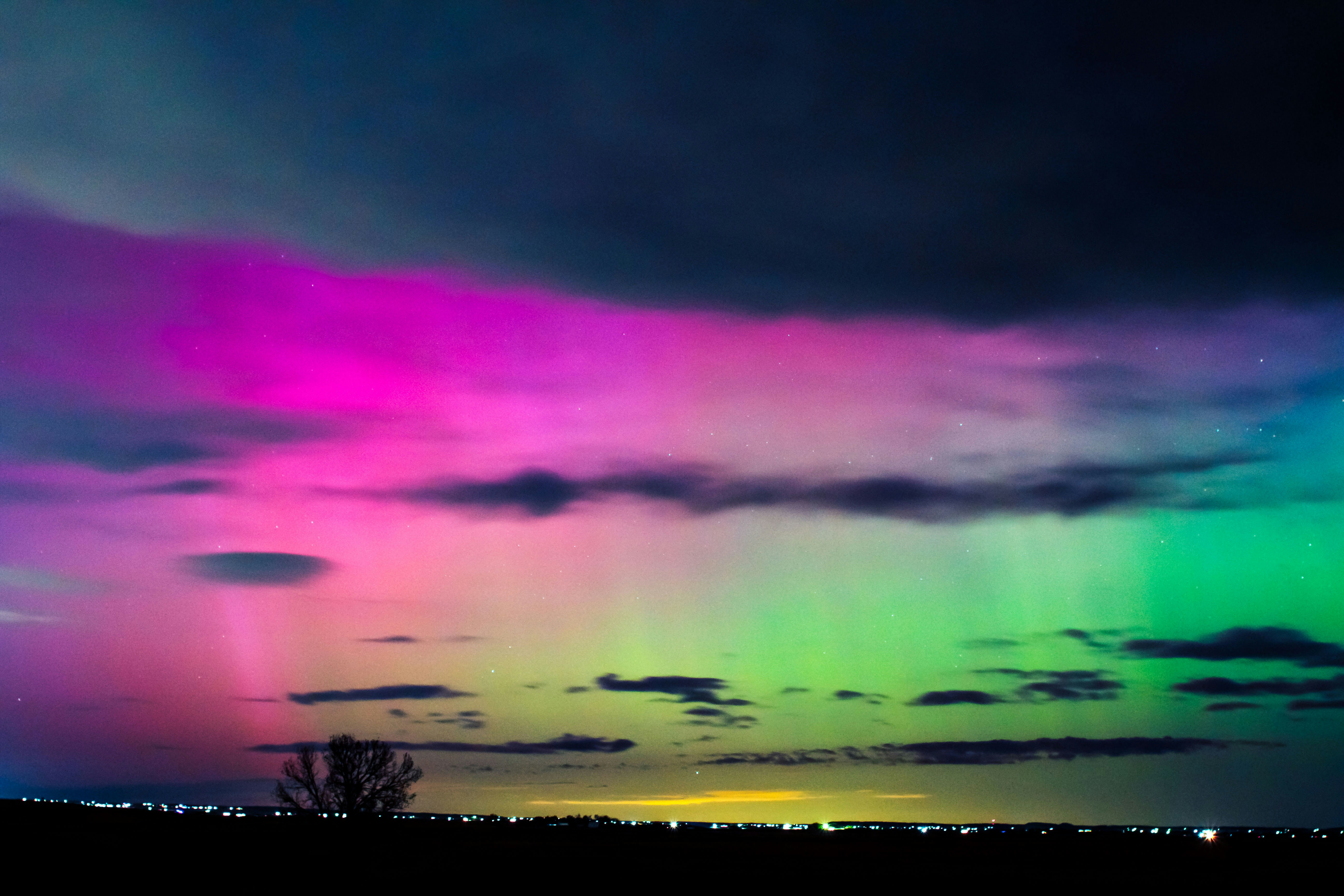 a very colorful sky with some clouds and trees
