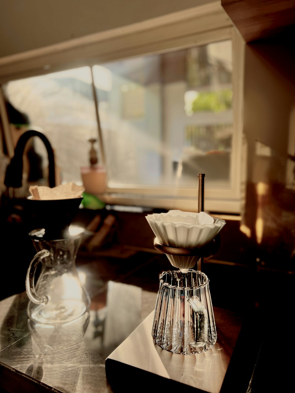 a table with a glass pitcher and a coffee pot on top of it