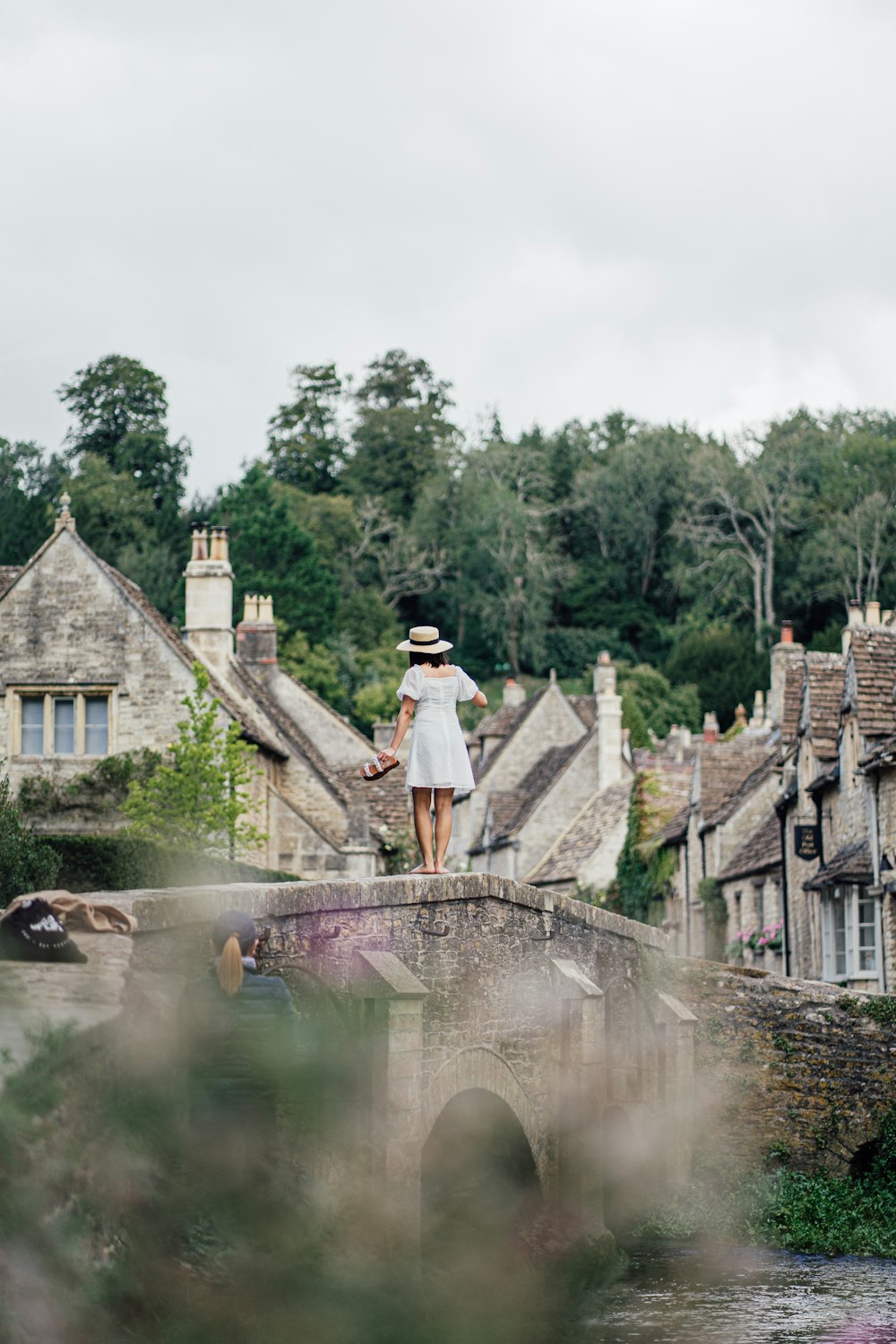 a woman standing on a bridge over a river