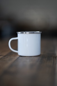 a white cup sitting on top of a wooden table