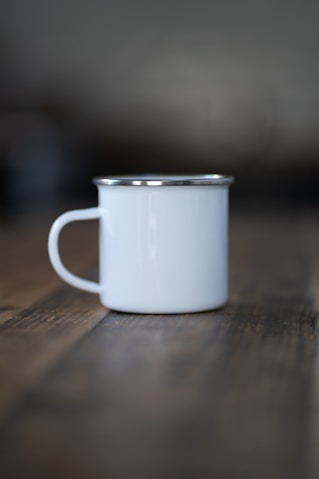 a white cup sitting on top of a wooden table