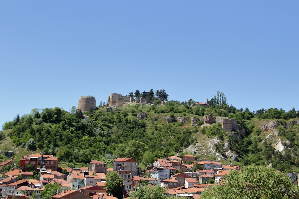 a small village on a hill with a castle in the background