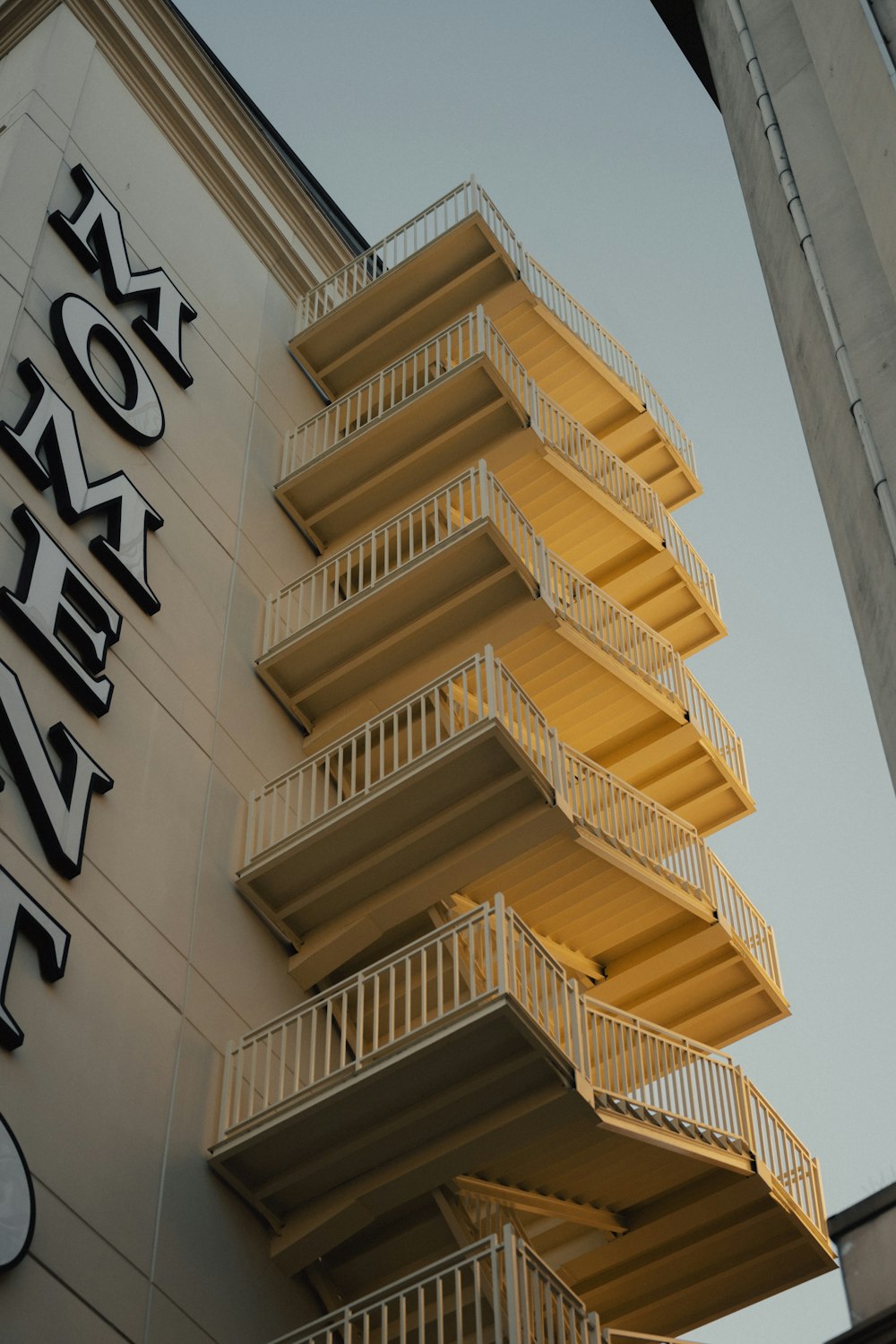 a tall building with balconies next to a clock tower